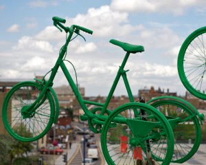 green painted adult's trike against an aerial view of Gravesend