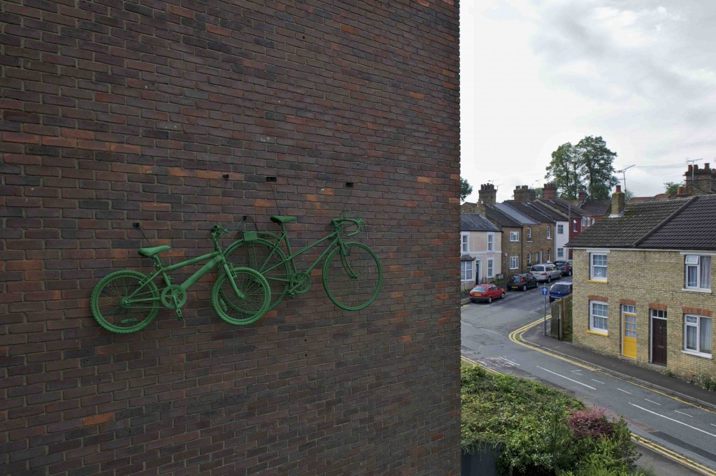 A green painted racer & mountain bike 'race' across the wall